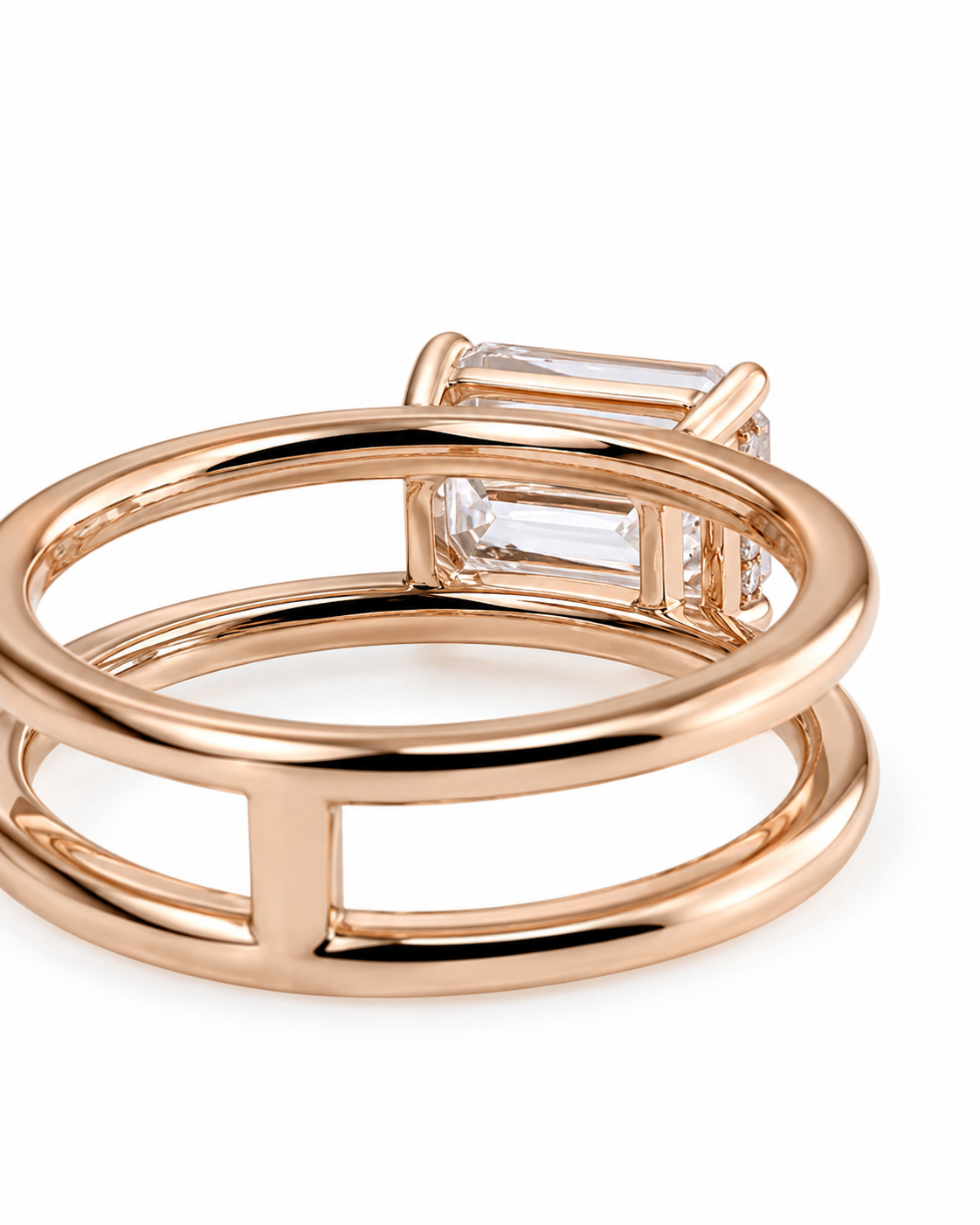 color_10K_RG, color_14K_RG &&A close-up of a rose gold ring with a double-band design and a clear rectangular baguette gemstone, shown on a white background.