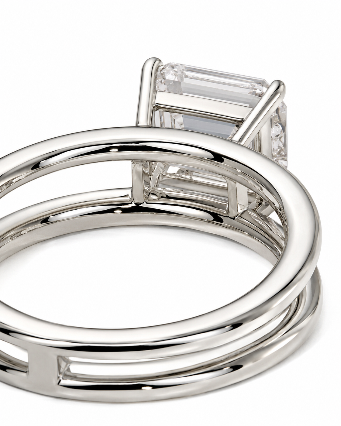 color_925_SIL,color_935_ARG,color_10K_WG, color_14K_WG &&A close-up of a silver-toned ring featuring a rectangular baguette-cut clear gemstone in a prong setting, with a split-band design.