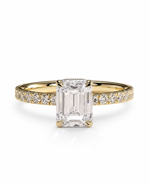 color_10K_YG, color_14K_YG &&An emerald-cut diamond engagement ring in yellow gold with pave diamonds on the band, set against a clean white background.