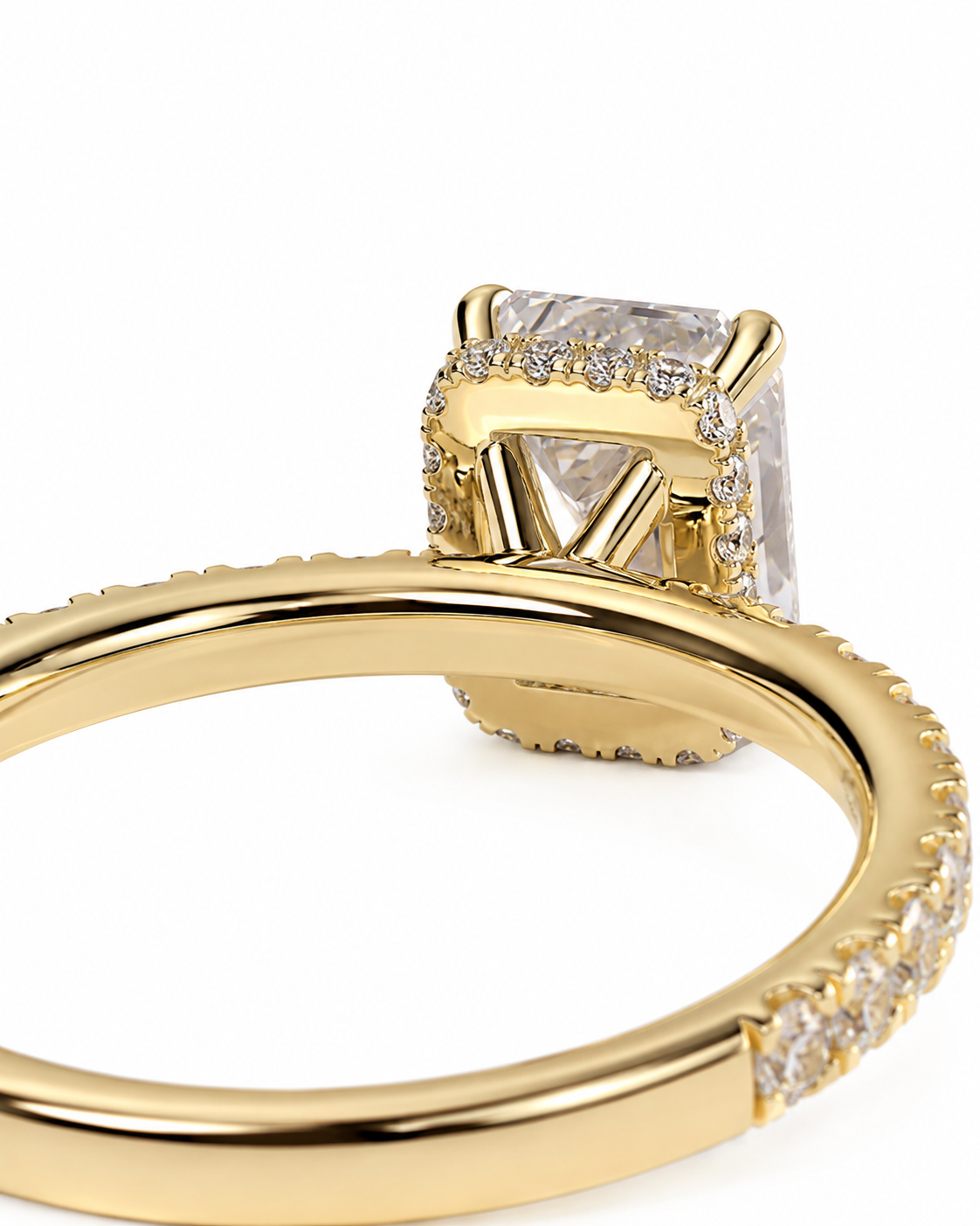 color_10K_YG, color_14K_YG &&A close-up shot of a gold ring featuring a rectangular clear gemstone in a halo setting, with a pave-set diamond band, on a white background.