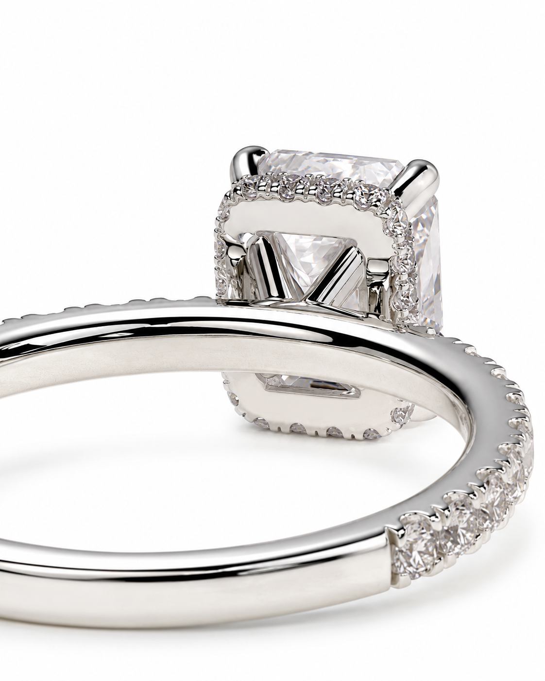 color_925_SIL,color_935_ARG,color_10K_WG, color_14K_WG &&A close-up shot of a silver-toned ring featuring a cushion-cut diamond center stone surrounded by a halo of small pave-set diamonds, with a matching diamond-accented band.