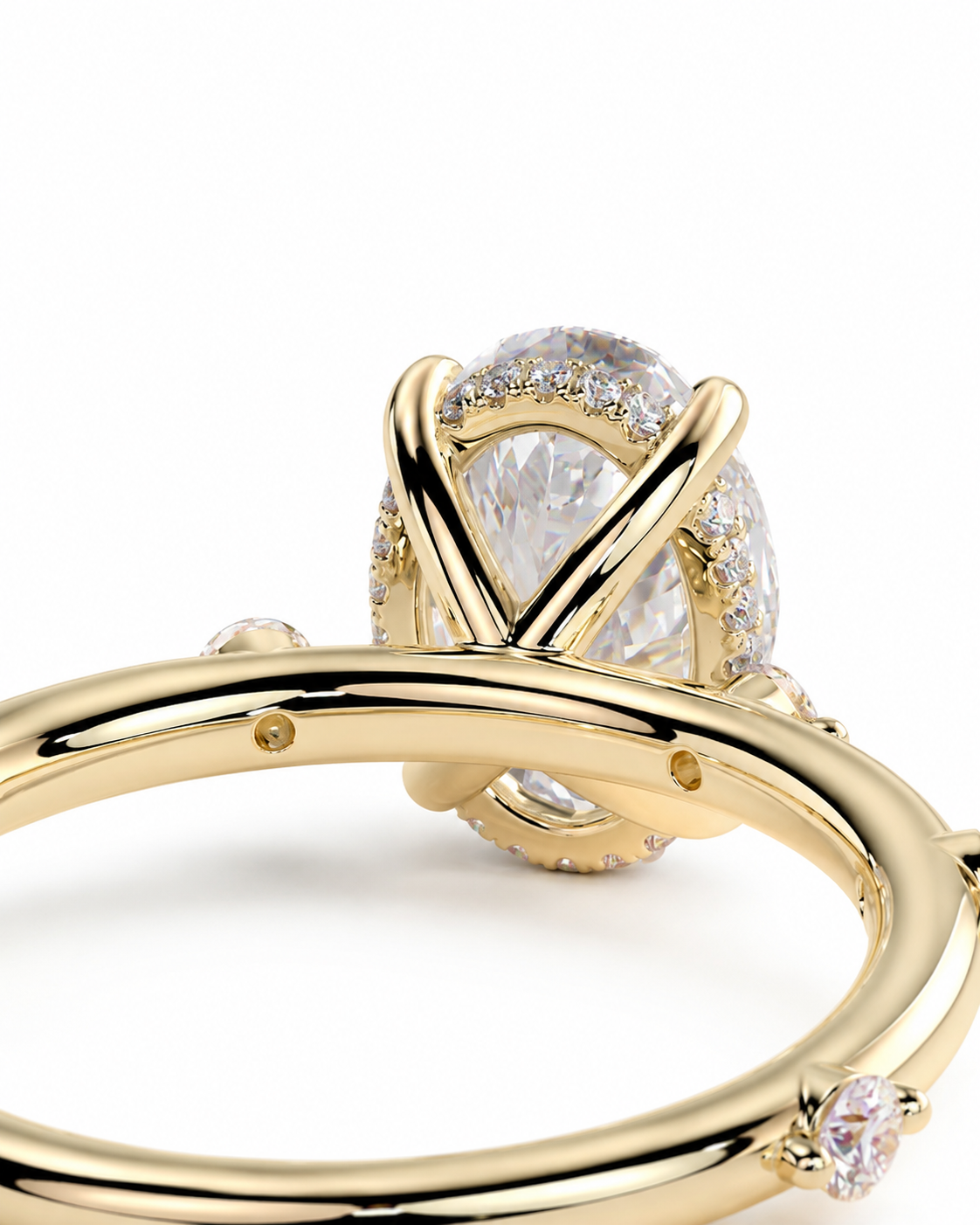 color_10K_YG, color_14K_YG &&A close-up of a yellow gold ring featuring a large pear-cut clear center stone in a prong setting, accented by small pave diamonds and a small round diamond on the band, set against a plain white background.