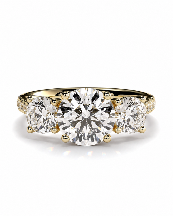 color_10K_YG, color_14K_YG &&A three-stone diamond ring featuring a large round center diamond flanked by two smaller round diamonds, set in a yellow gold band with small accent diamonds on the shoulders, shown on a clean white background.
