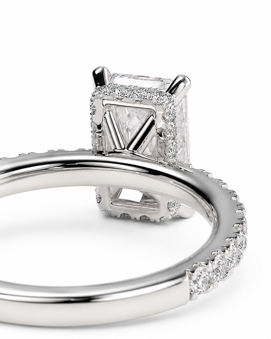 color_925_SIL,color_935_ARG,color_10K_WG, color_14K_WG &&A close-up studio shot of a silver-toned ring featuring a rectangular clear gemstone in a prong setting, surrounded by a halo of small clear stones, with a pave-set band.