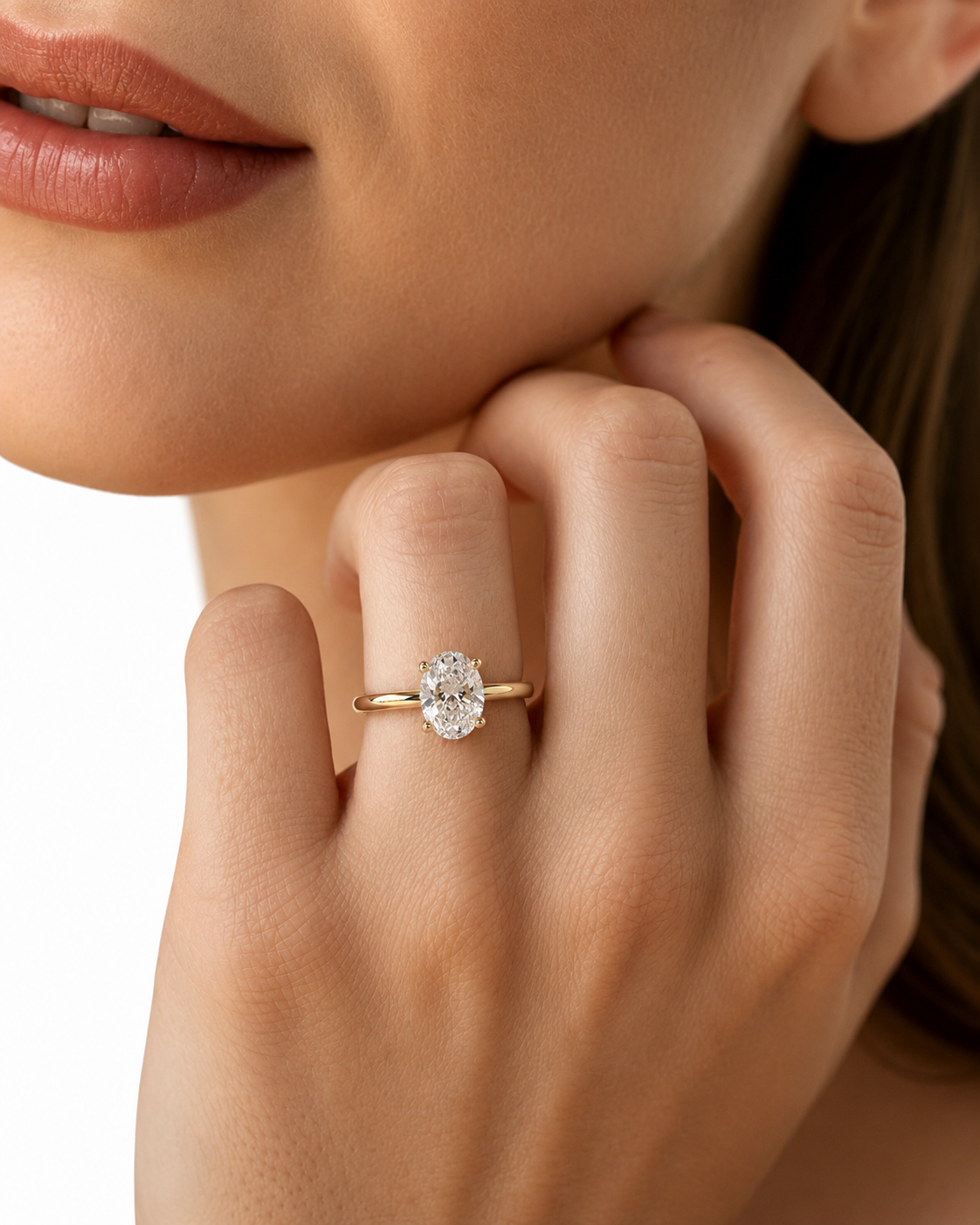color_10K_YG, color_14K_YG &&A close-up lifestyle shot of a model's hand wearing a yellow gold ring with a round brilliant-cut diamond. The background is a clean white studio backdrop.