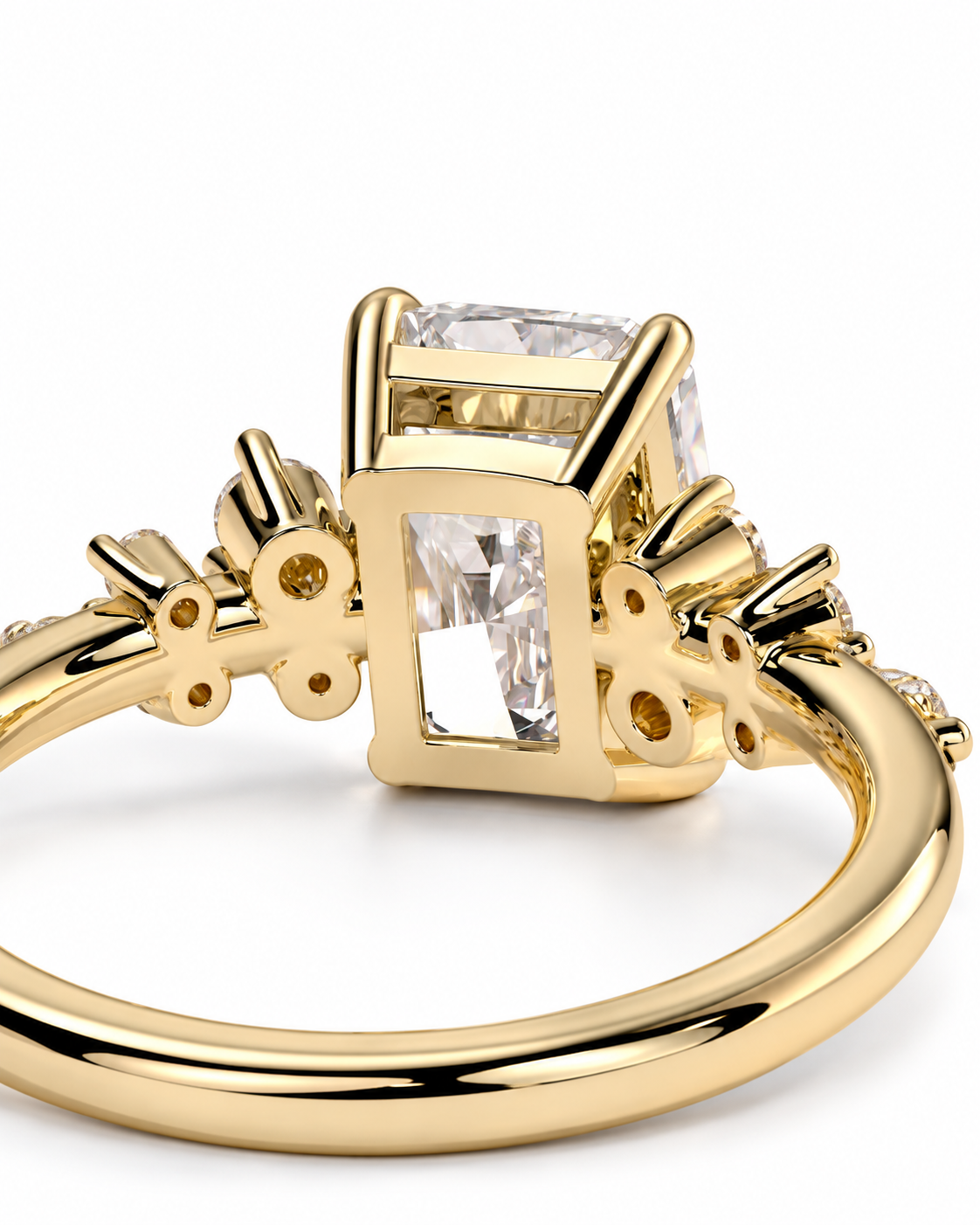 color_10K_YG, color_14K_YG &&A close-up shot of a yellow gold ring featuring a rectangular clear gemstone in a square-shaped setting, with decorative floral details on the band, set against a plain white background.