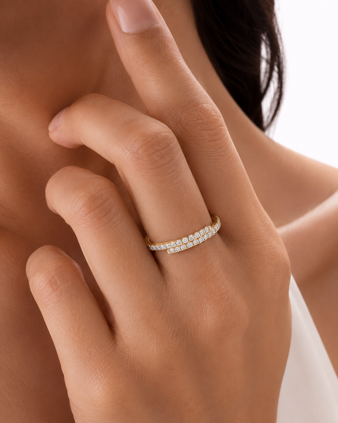 color_10K_YG, color_14K_YG &&A close-up of a model's hand wearing a delicate yellow gold eternity ring set with small round diamonds. The ring is shown on the ring finger against a clean, bright white background.