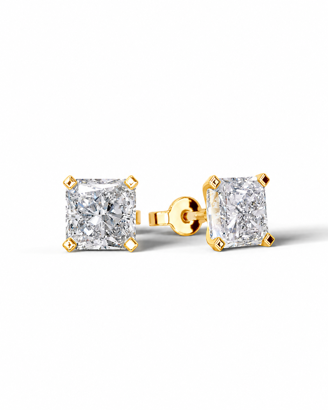 color_10K_YG, color_14K_YG &&A pair of yellow gold stud earrings with princess-cut clear diamonds, shown on a clean white background. One earring is facing forward, displaying the diamond and its gold prongs, while the other is turned to show the post and backing.