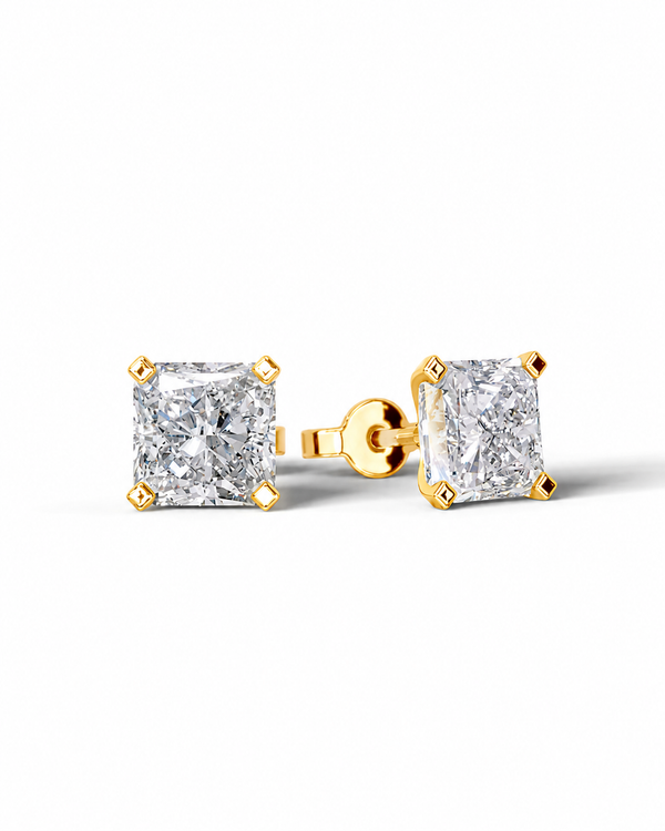 color_10K_YG, color_14K_YG &&A pair of yellow gold stud earrings with princess-cut clear diamonds, shown on a clean white background. One earring is facing forward, displaying the diamond and its gold prongs, while the other is turned to show the post and backing.