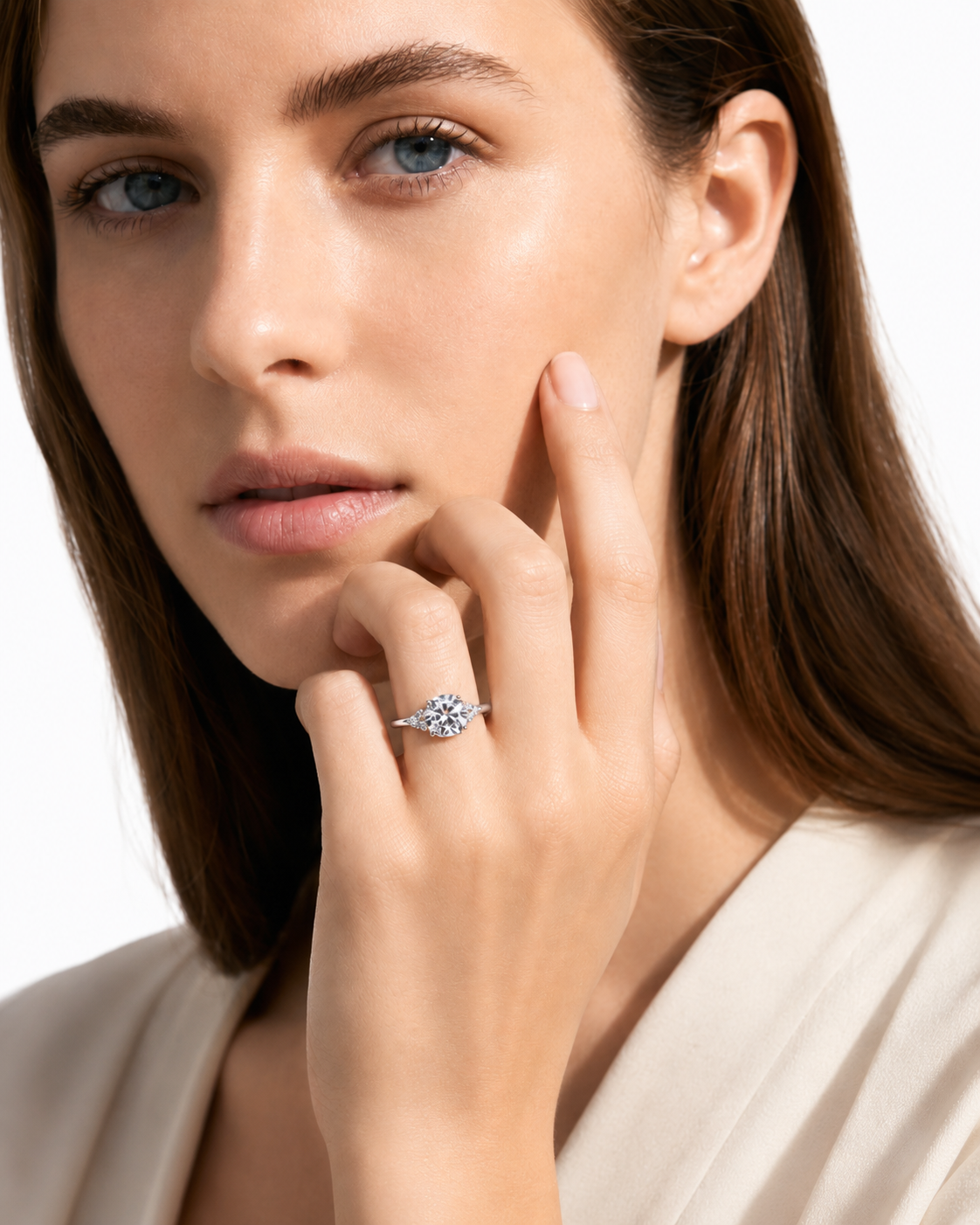 color_925_SIL,color_935_ARG,color_10K_WG, color_14K_WG &&A close-up of a woman with long brown hair wearing a delicate silver ring with a small clear gemstone on her finger, set against a clean white background.