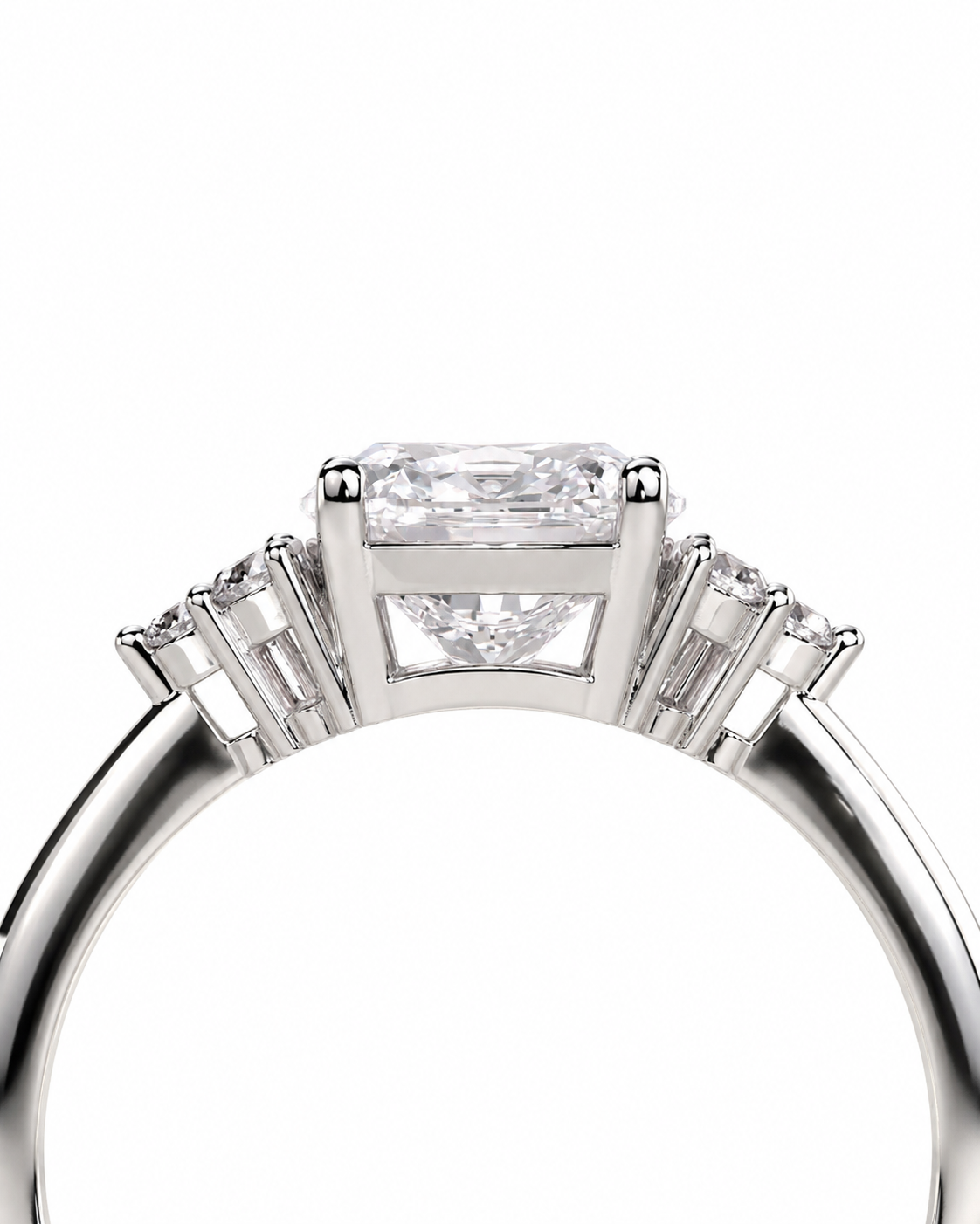 color_925_SIL,color_935_ARG,color_10K_WG, color_14K_WG &&A close-up studio shot of a silver-toned ring featuring a rectangular baguette-cut center diamond and smaller side diamonds, set against a plain white background.