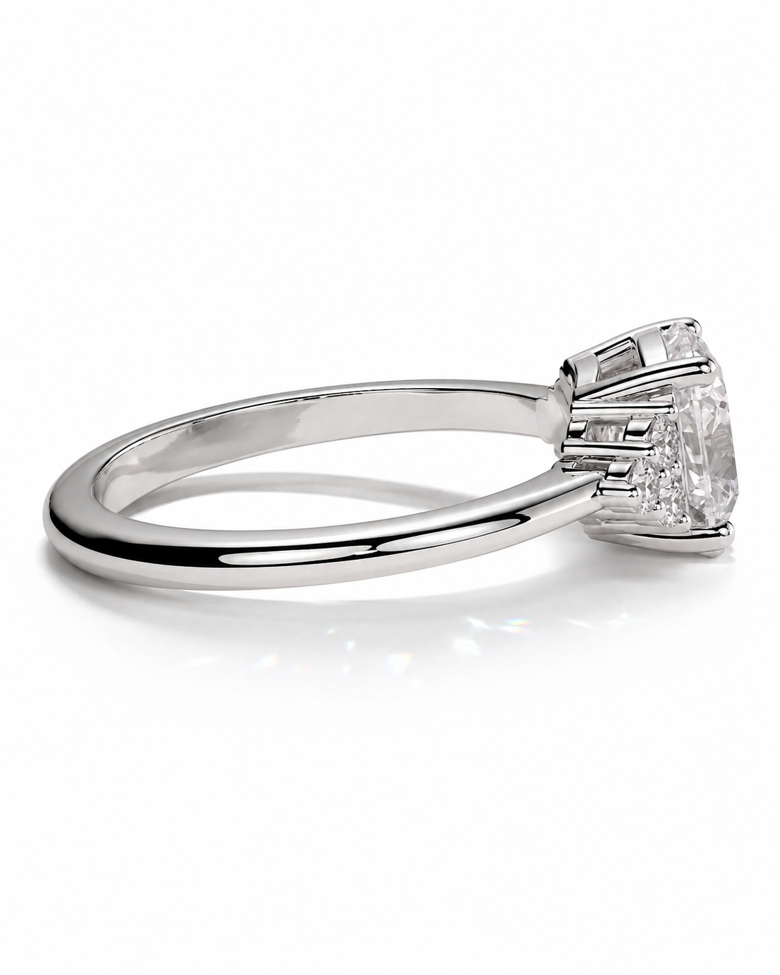 color_925_SIL,color_935_ARG,color_10K_WG, color_14K_WG &&A silver-toned diamond engagement ring with a round center stone and baguette side stones, shown in a three-quarter side view on a white background.