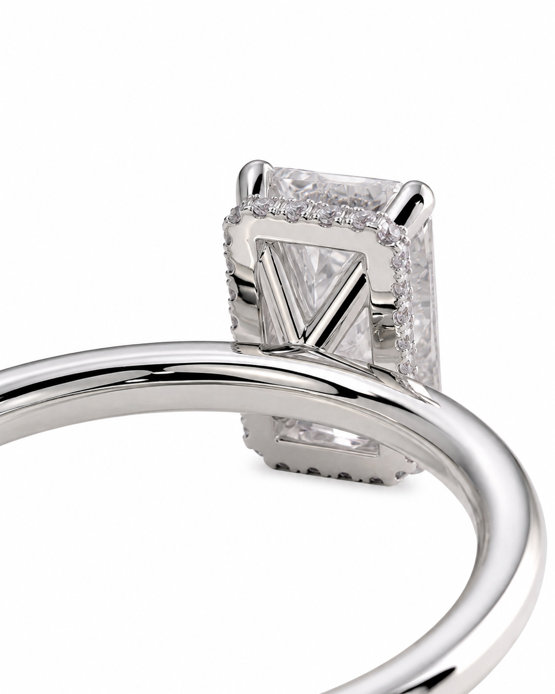 color_925_SIL,color_935_ARG,color_10K_WG, color_14K_WG &&A close-up studio shot of a silver-toned ring featuring a rectangular clear gemstone in a prong setting with a V-shaped center accent and small surrounding stones, shown against a plain white background.