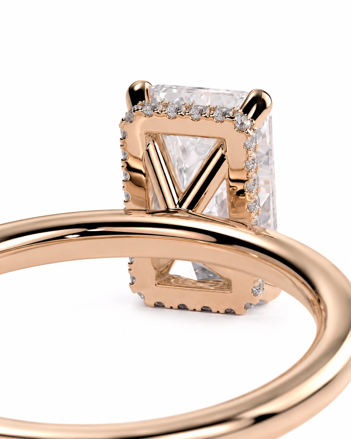 color_10K_RG, color_14K_RG &&A close-up of a rose gold ring featuring  large rectangular clear gemstone with a prominent V-shaped center prong and small accent stones, set against a plain white background.