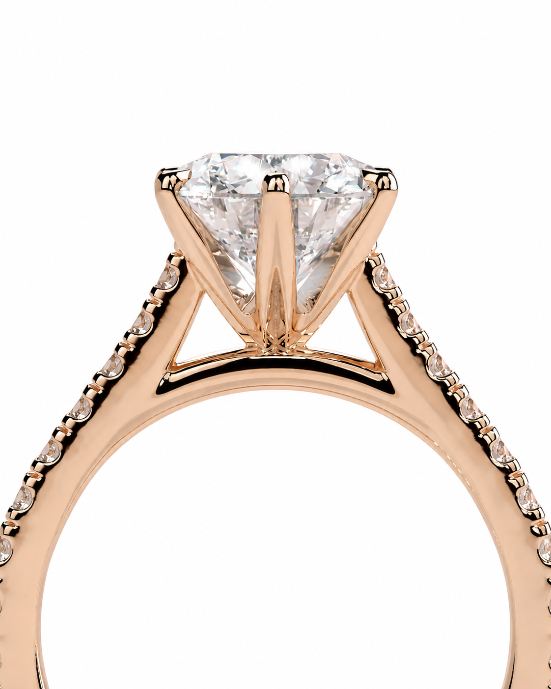 color_10K_RG, color_14K_RG &&A close-up of a rose gold engagement ring featuring a large round brilliant-cut diamond center stone in a four-prong setting, with pavé diamonds along the shoulders of the band, set against a plain white background.
