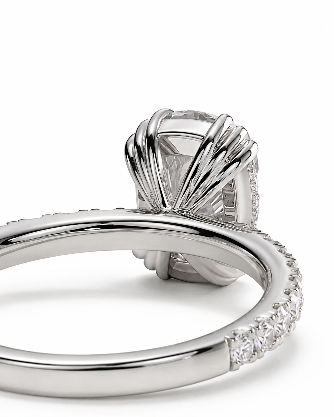 color_925_SIL,color_935_ARG,color_10K_WG, color_14K_WG &&A close-up studio shot of a silver-toned ring with a large clear gemstone in a textured, fan-like setting and a smooth band with small clear stones along the side, on a white background.