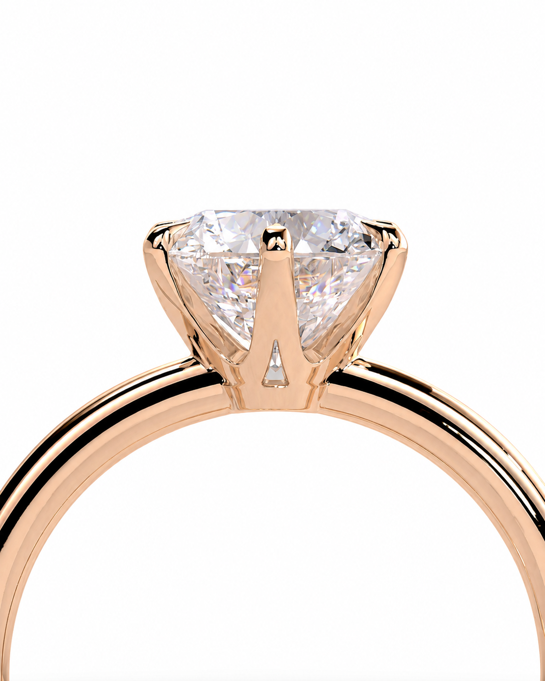 color_10K_RG, color_14K_RG &&A close-up of a rose gold solitaire engagement ring featuring a brilliant round-cut diamond in a four-prong setting, shown against a solid white background.