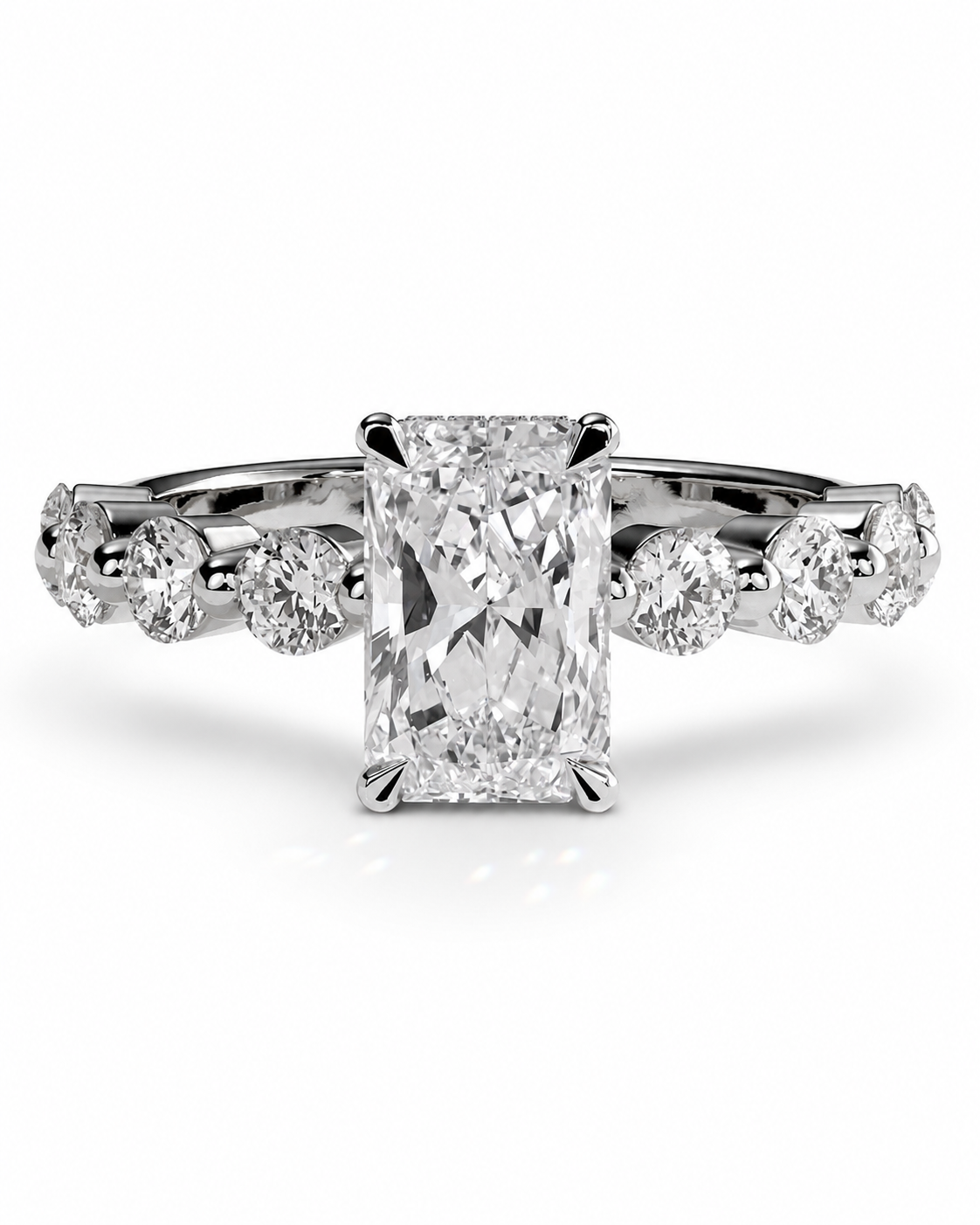color_925_SIL,color_935_ARG,color_10K_WG, color_14K_WG &&A radiant cut diamond engagement ring with a halo setting and smaller round diamonds along the band, shown on a clean white background.