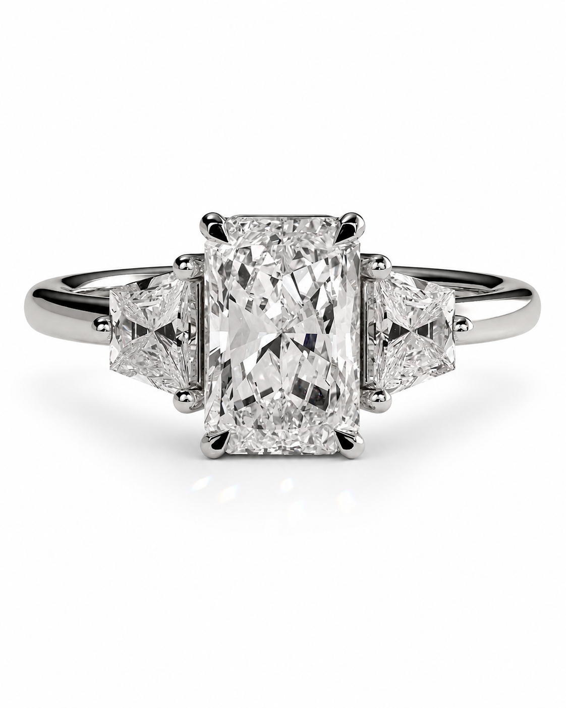 color_925_SIL,color_935_ARG,color_10K_WG, color_14K_WG &&A three-stone diamond ring featuring a large rectangular emerald-cut center stone flanked by two smaller triangular-cut side stones, set in a polished silver-colored metal band on a clean white background.