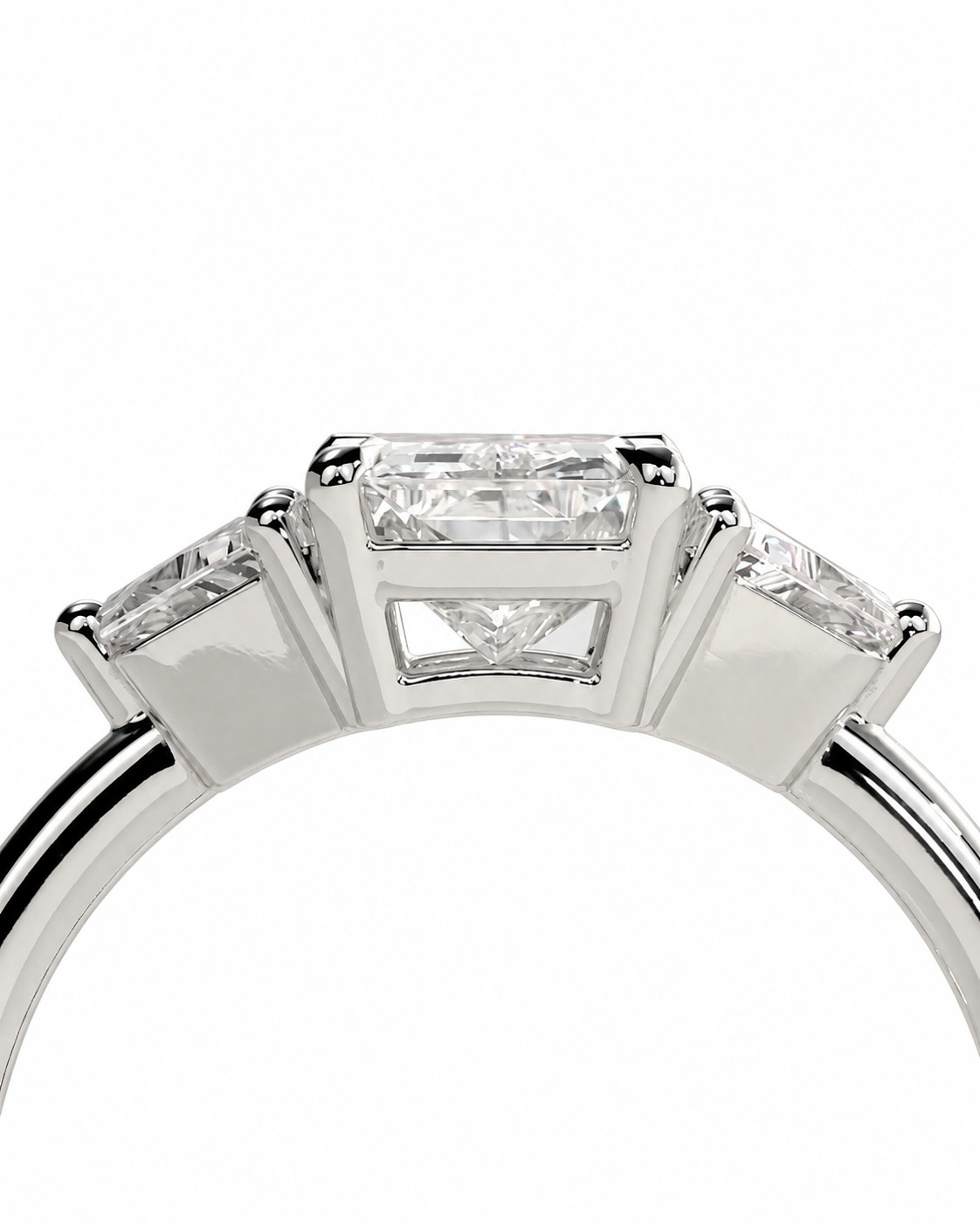 color_925_SIL,color_935_ARG,color_10K_WG, color_14K_WG &&A close-up studio shot of a silver-toned ring featuring a central rectangular baguette-cut diamond flanked by two smaller round-cut diamonds on a white background.