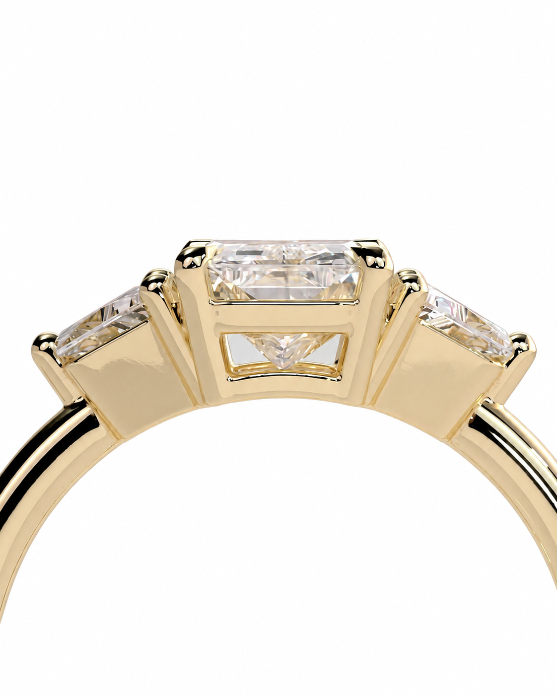 color_10K_YG, color_14K_YG &&A close-up of a yellow gold ring featuring a central rectangular baguette diamond flanked by two smaller round diamonds on the shoulders, set against a plain white background.
