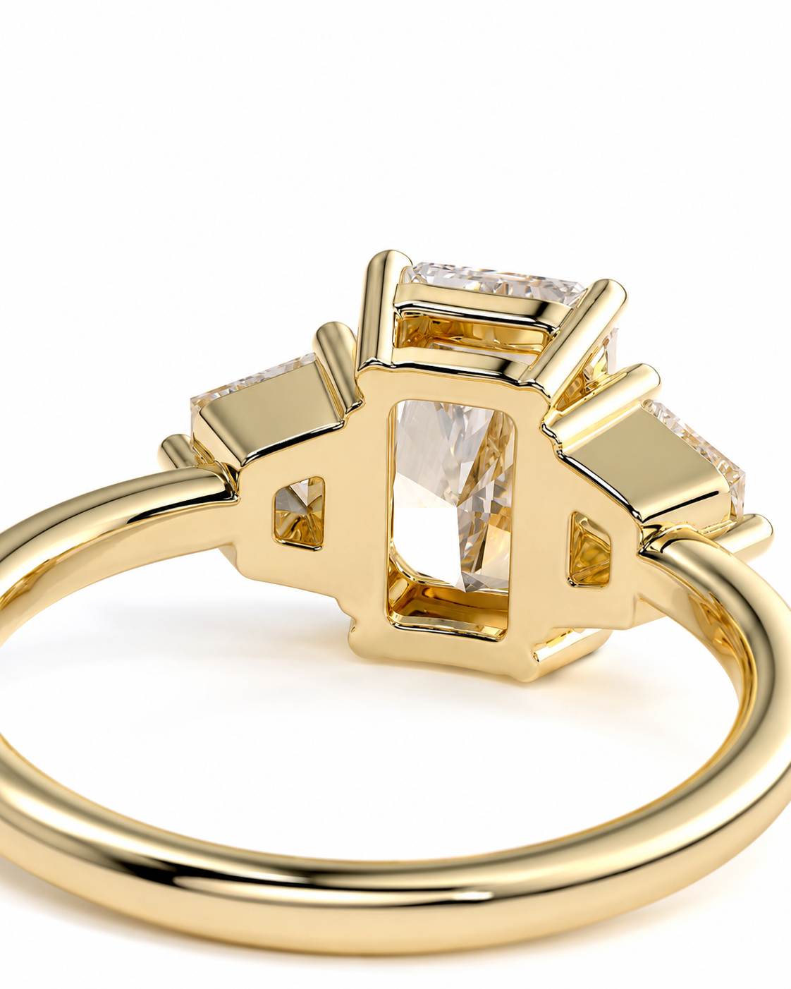 color_10K_YG, color_14K_YG &&A close-up shot of a yellow gold ring featuring a large rectangular clear gemstone in a prong setting, flanked by smaller side stones, on a white background.