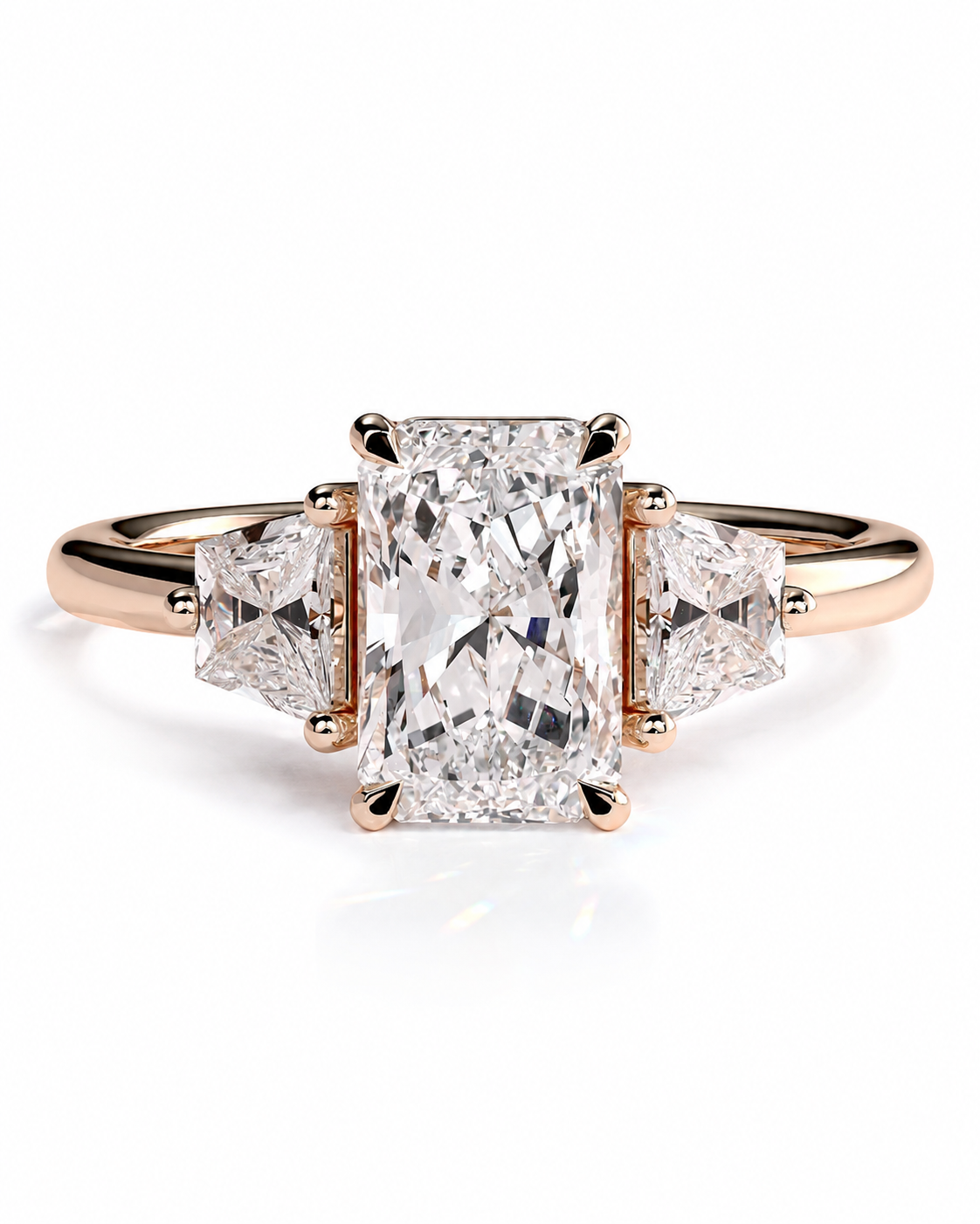 color_10K_RG, color_14K_RG &&A rose gold engagement ring featuring a large rectangular emerald-cut center diamond flanked by two smaller triangle-cut side diamonds, set on a polished band against a white background.