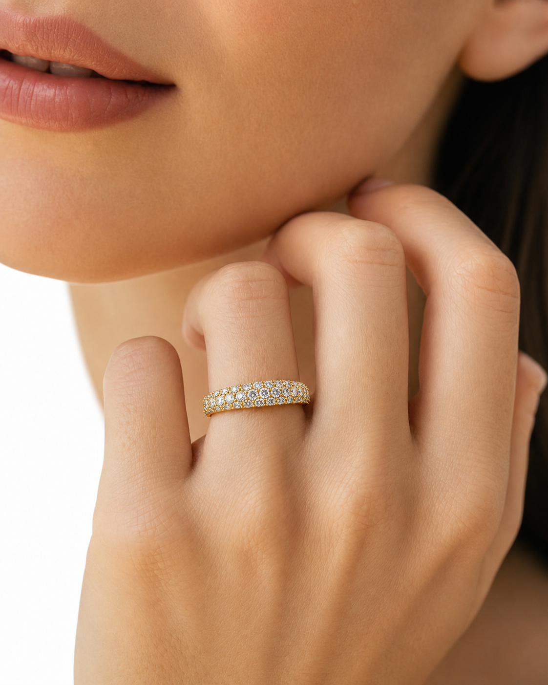 color_10K_YG, color_14K_YG &&A close-up of a woman's hand wearing a delicate gold band ring set with small clear stones, against a clean white background.