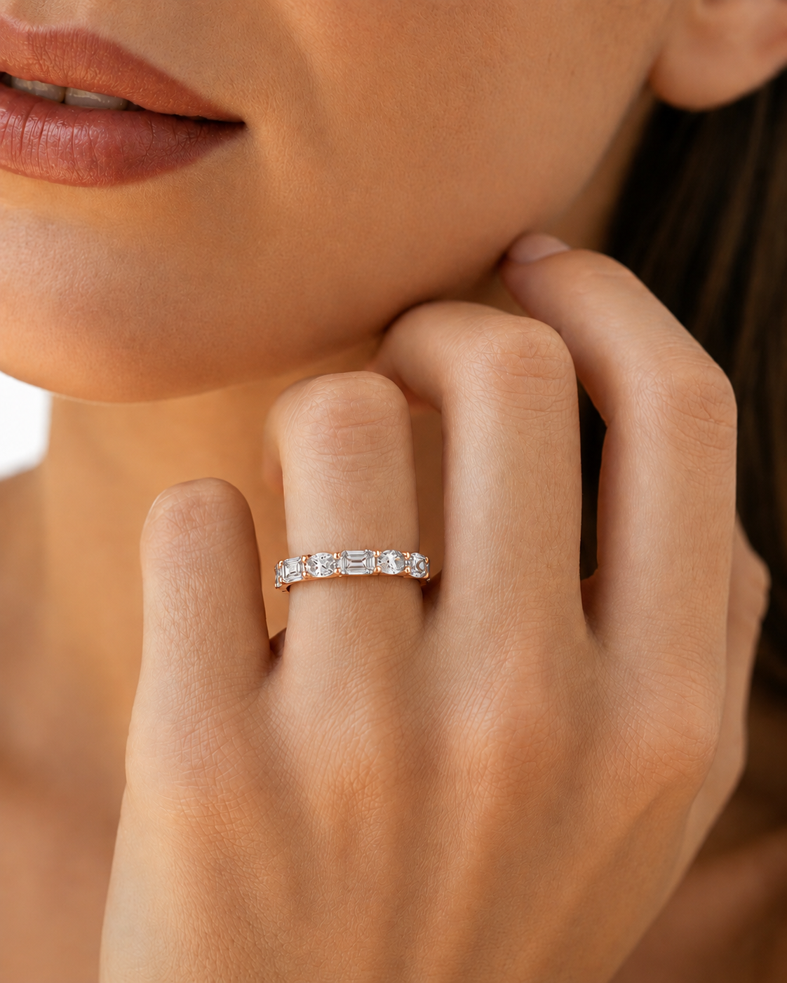 color_10K_RG, color_14K_RG &&A close-up of a woman's hand wearing a slim diamond eternity ring with baguette-cut diamonds on a white gold or platinum band.