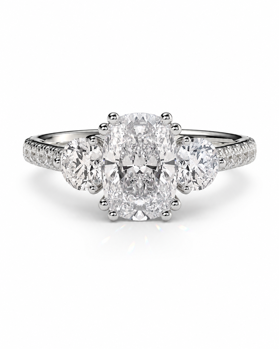 color_925_SIL,color_935_ARG,color_10K_WG, color_14K_WG &&A three-stone diamond engagement ring featuring a large oval center diamond flanked by two round diamonds, set on a silver-colored band with small accent diamonds, shown on a clean white background.