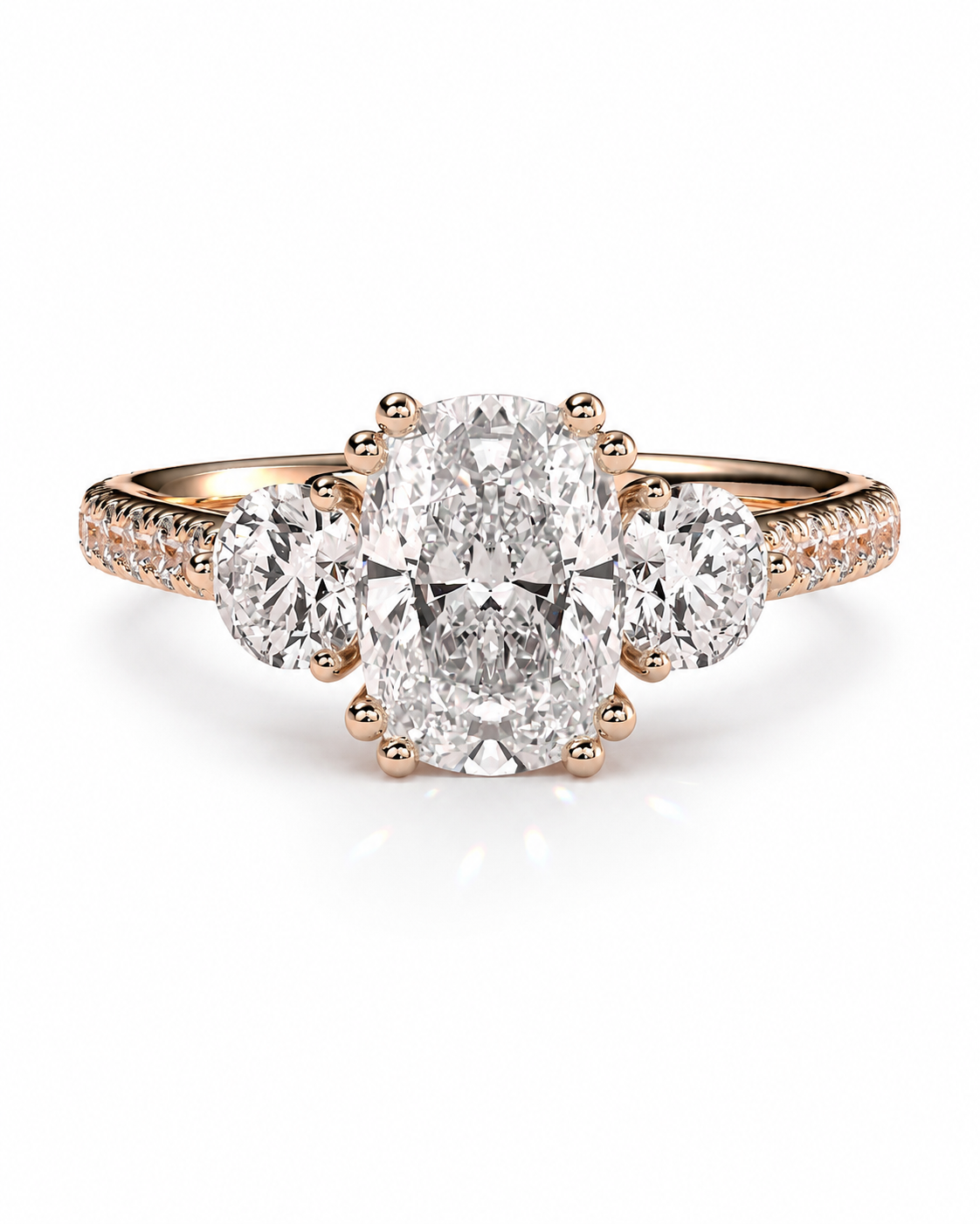 color_10K_RG, color_14K_RG &&A rose gold three-stone engagement ring featuring a large oval center diamond flanked by two round side diamonds, with small pavé diamonds on the band, set against a clean white background.