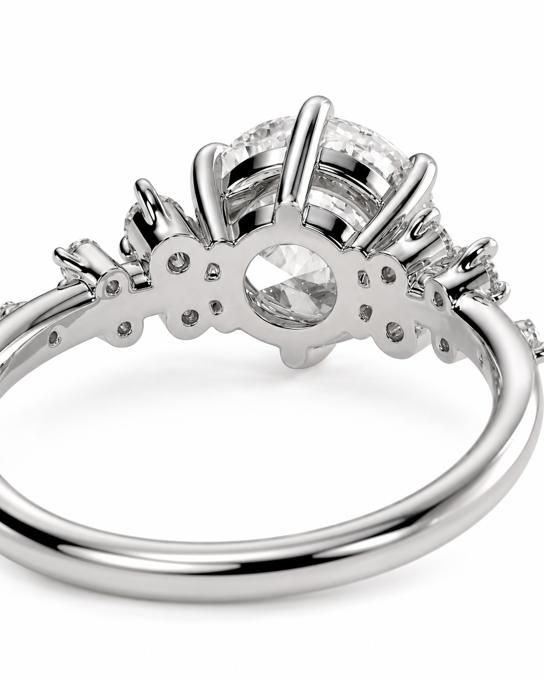 color_925_SIL,color_935_ARG,color_10K_WG, color_14K_WG &&A close-up studio shot of a silver-toned ring with a large round clear center stone and smaller surrounding stones, shown on a plain white background.