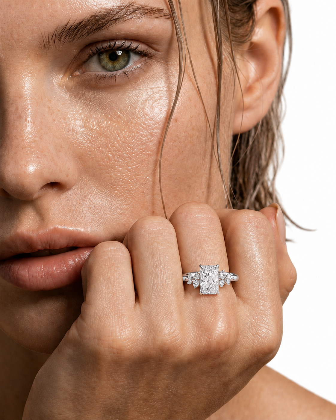 color_925_SIL,color_935_ARG,color_10K_WG, color_14K_WG &&A close-up lifestyle shot of a model wearing a diamond engagement ring on her finger, with her hand resting near her chin against a clean white background.