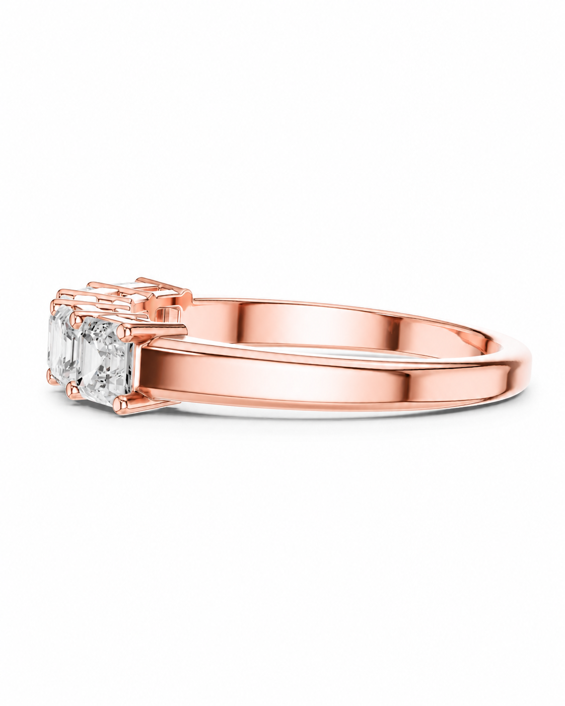 color_10K_RG, color_14K_RG &&A rose gold ring featuring three baguette-cut clear gemstones in a prong setting, shown from a side profile on a clean white background.