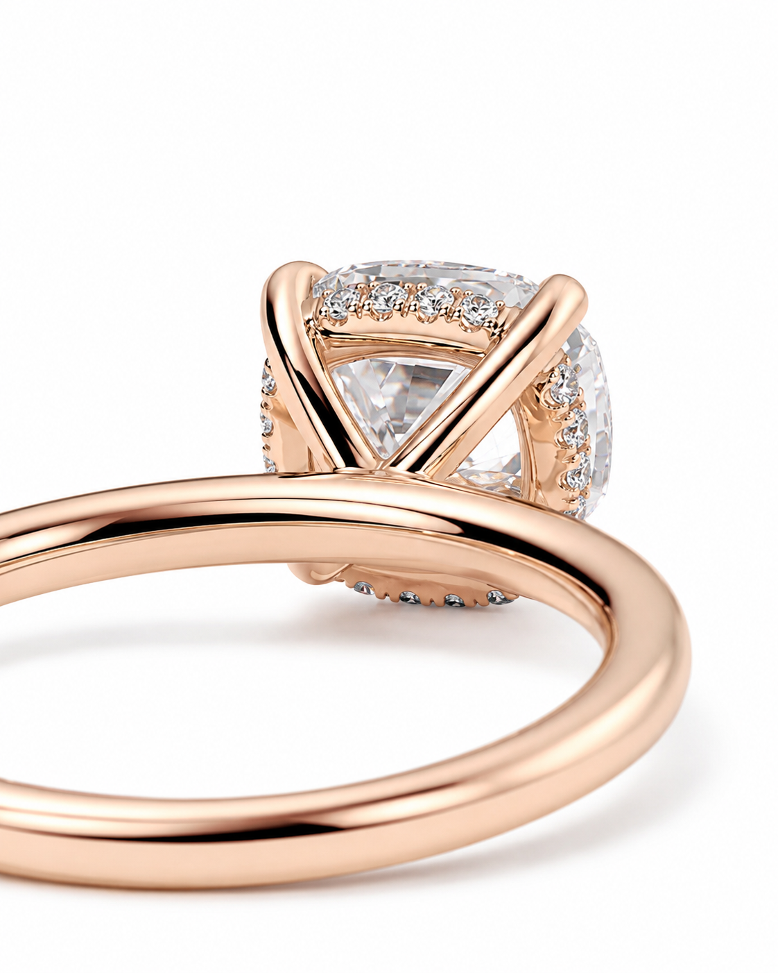 color_10K_RG, color_14K_RG &&A close-up of a rose gold ring featuring a triangular-cut clear center stone surrounded by a halo of small clear stones, set on a polished band.