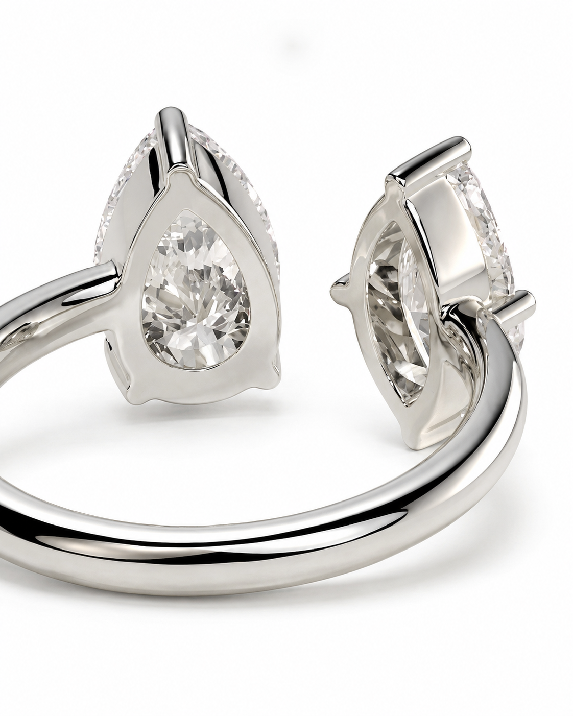 color_925_SIL,color_935_ARG,color_10K_WG, color_14K_WG &&A close-up studio shot of a silver-toned ring with a pear-cut clear gemstone in a triangular setting, shown from two angles on a white background.