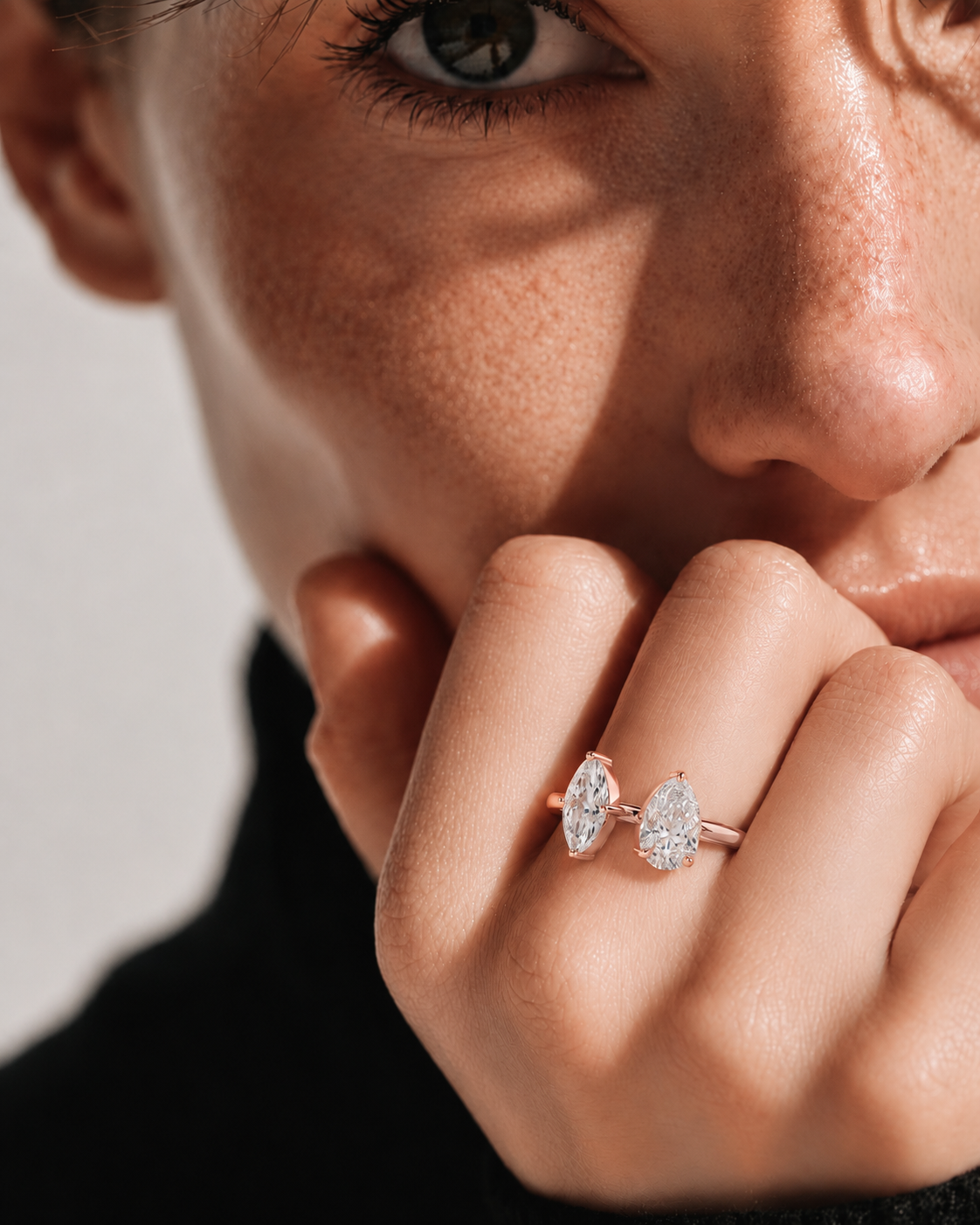 color_10K_RG, color_14K_RG &&A close-up lifestyle shot of a model wearing a rose gold ring with marquise-cut and round brilliant-cut clear gemstones on her finger.