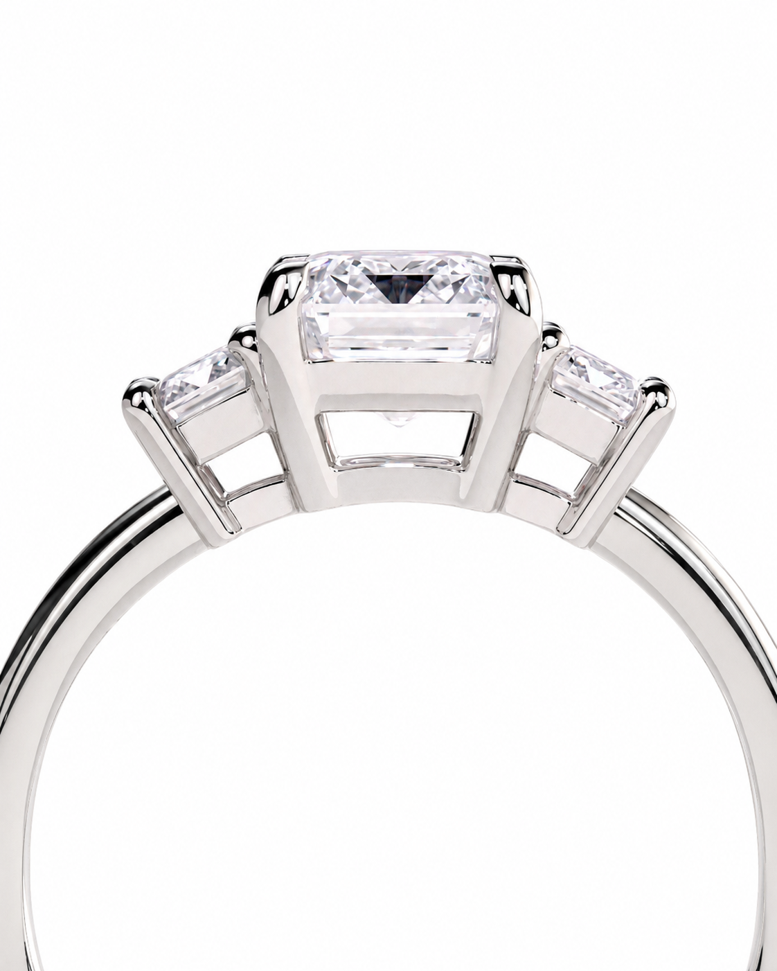 color_925_SIL,color_935_ARG,color_10K_WG, color_14K_WG &&A close-up studio shot of a silver-toned ring featuring a rectangular clear center stone with two smaller side stones, set against a plain white background.