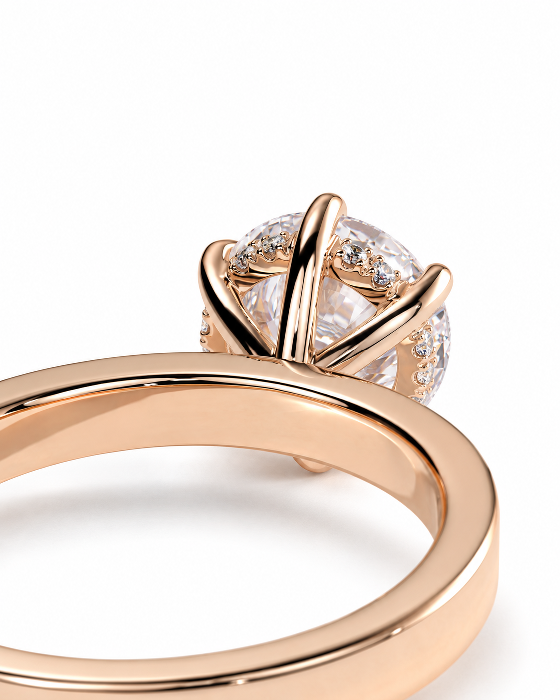 color_10K_RG, color_14K_RG &&A close-up of a rose gold ring featuring a large round clear gemstone in a claw setting, with smaller accent stones along the band, shown on a white background.