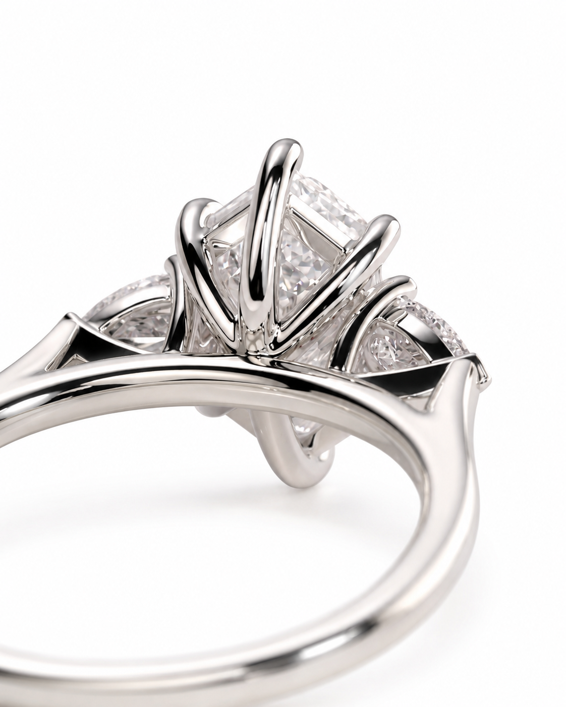 color_925_SIL,color_935_ARG,color_10K_WG, color_14K_WG &&A close-up studio shot of a silver-toned ring with a large clear gemstone in a prong setting, accented by smaller side stones, on a white background.