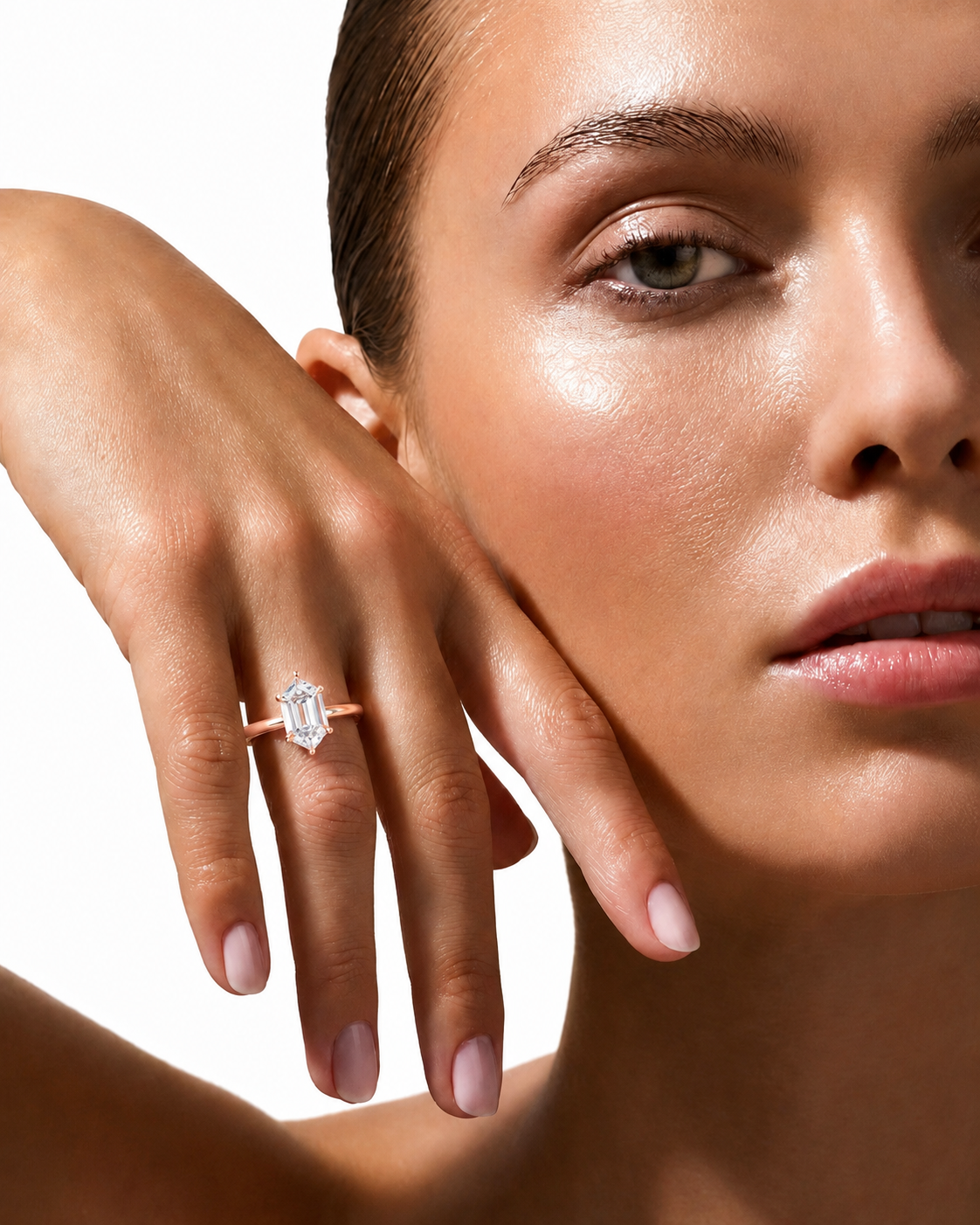 color_10K_RG, color_14K_RG &&
A close-up lifestyle shot of a model wearing a delicate gold ring with a rectangular baguette-cut clear gemstone on her ring finger, set against a clean white background.