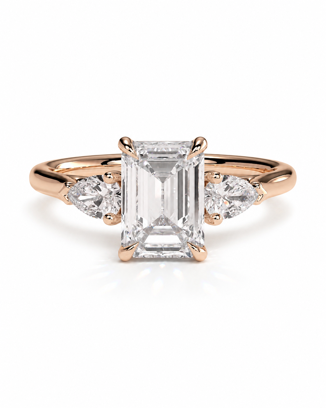color_10K_RG, color_14K_RG &&A rose gold engagement ring featuring a large emerald-cut center diamond flanked by two smaller round diamonds on a clean white background.