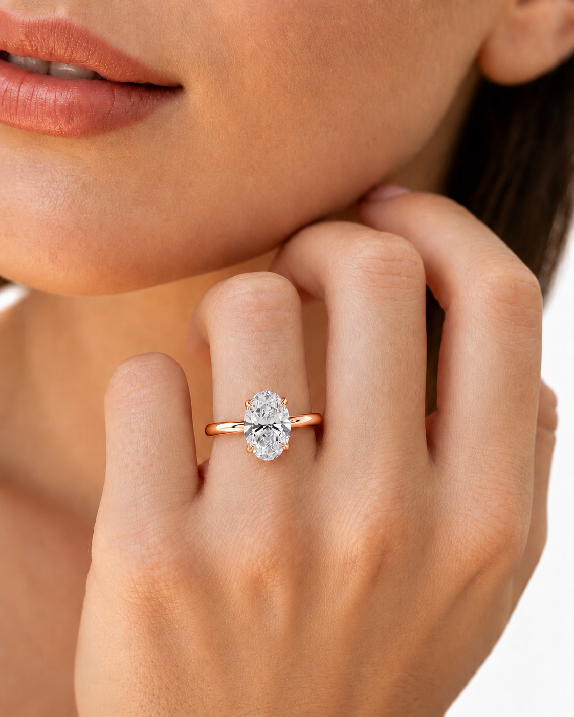 color_10K_RG, color_14K_RG &&A close-up lifestyle shot of a model wearing a rose gold engagement ring with a round-cut clear gemstone on her finger.