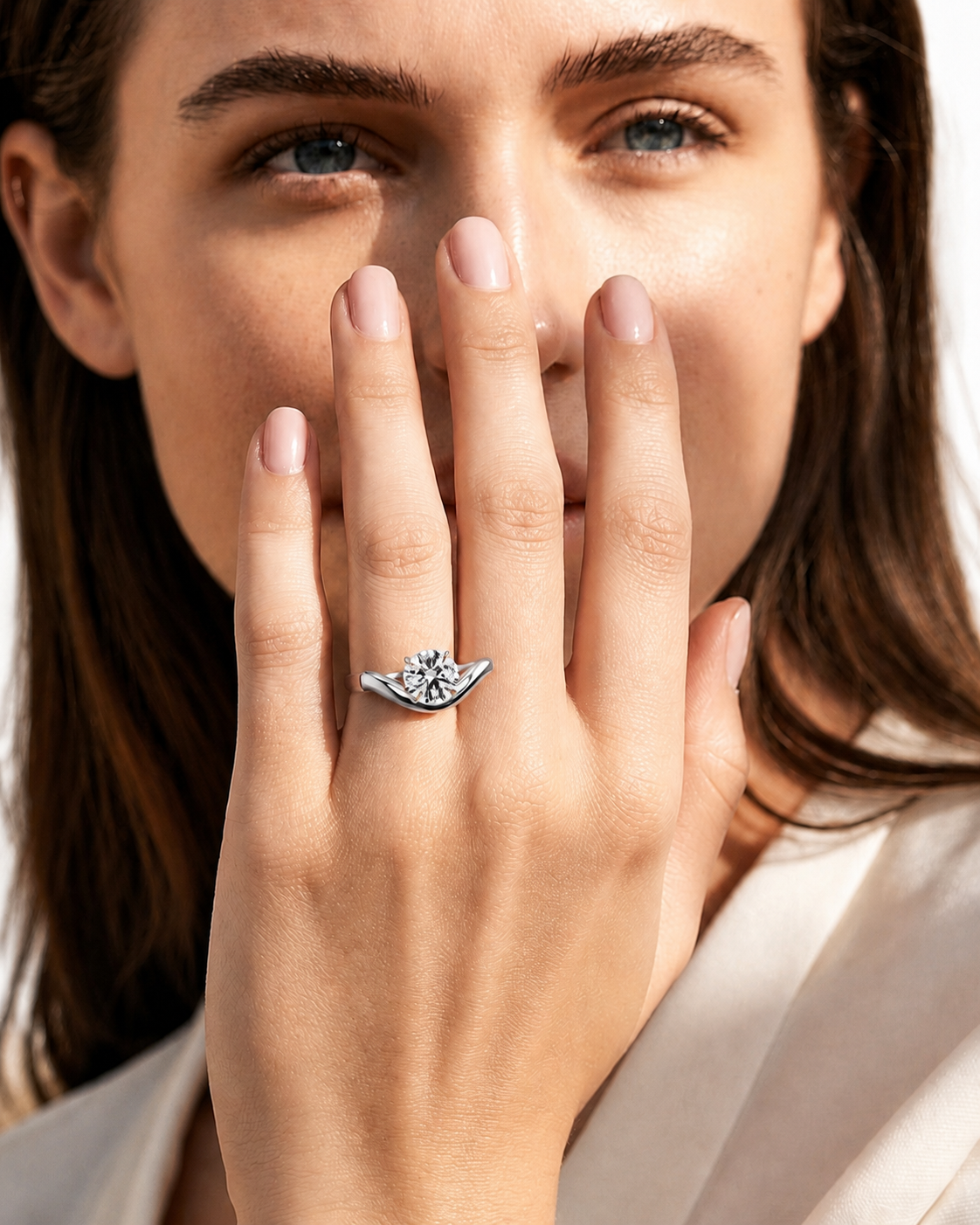 color_925_SIL,color_935_ARG,color_10K_WG, color_14K_WG &&A close-up lifestyle shot of a woman wearing a silver ring with a winged design and a central cluster of clear gemstones. Since a person is present, the subject_type is classified as Lifestyle.