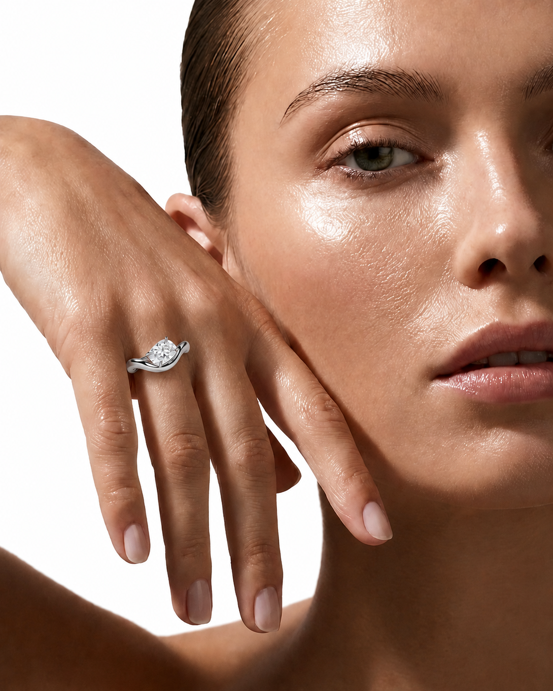 color_925_SIL,color_935_ARG,color_10K_WG, color_14K_WG &&A close-up lifestyle shot of a model wearing a silver-toned diamond engagement ring on her finger, with her hand resting against her cheek against a clean white background.