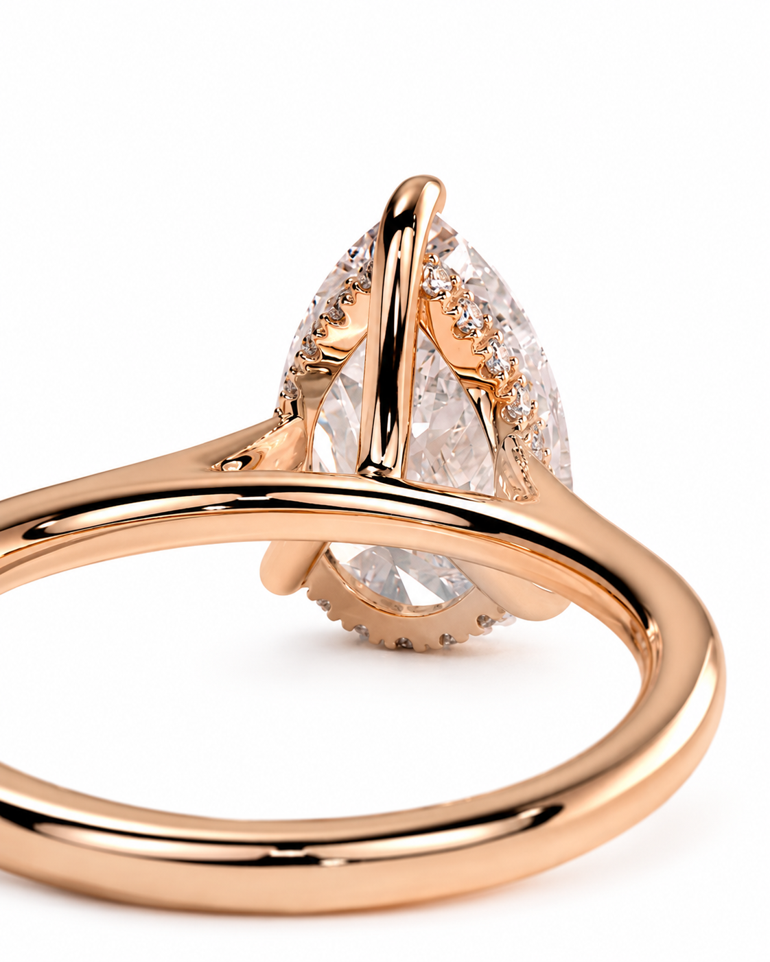 color_10K_RG, color_14K_RG &&A close-up of a rose gold ring featuring a large pear-cut clear center stone with smaller accent stones along the shoulders, set against a plain white background.