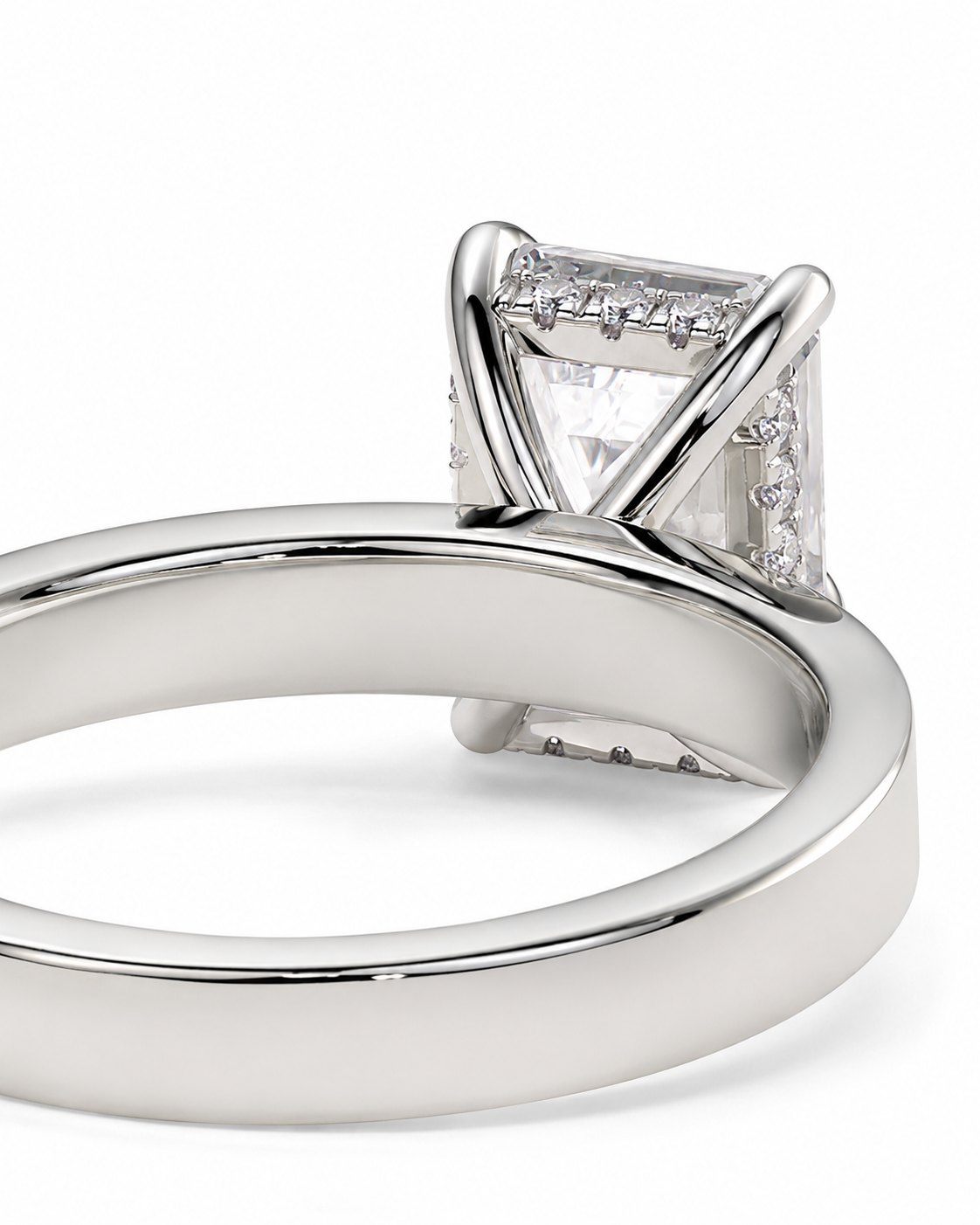 color_925_SIL,color_935_ARG,color_10K_WG, color_14K_WG &&A close-up shot of a silver-toned ring featuring a rectangular clear gemstone in a prong setting, with small accent stones along the sides, on a clean white background.