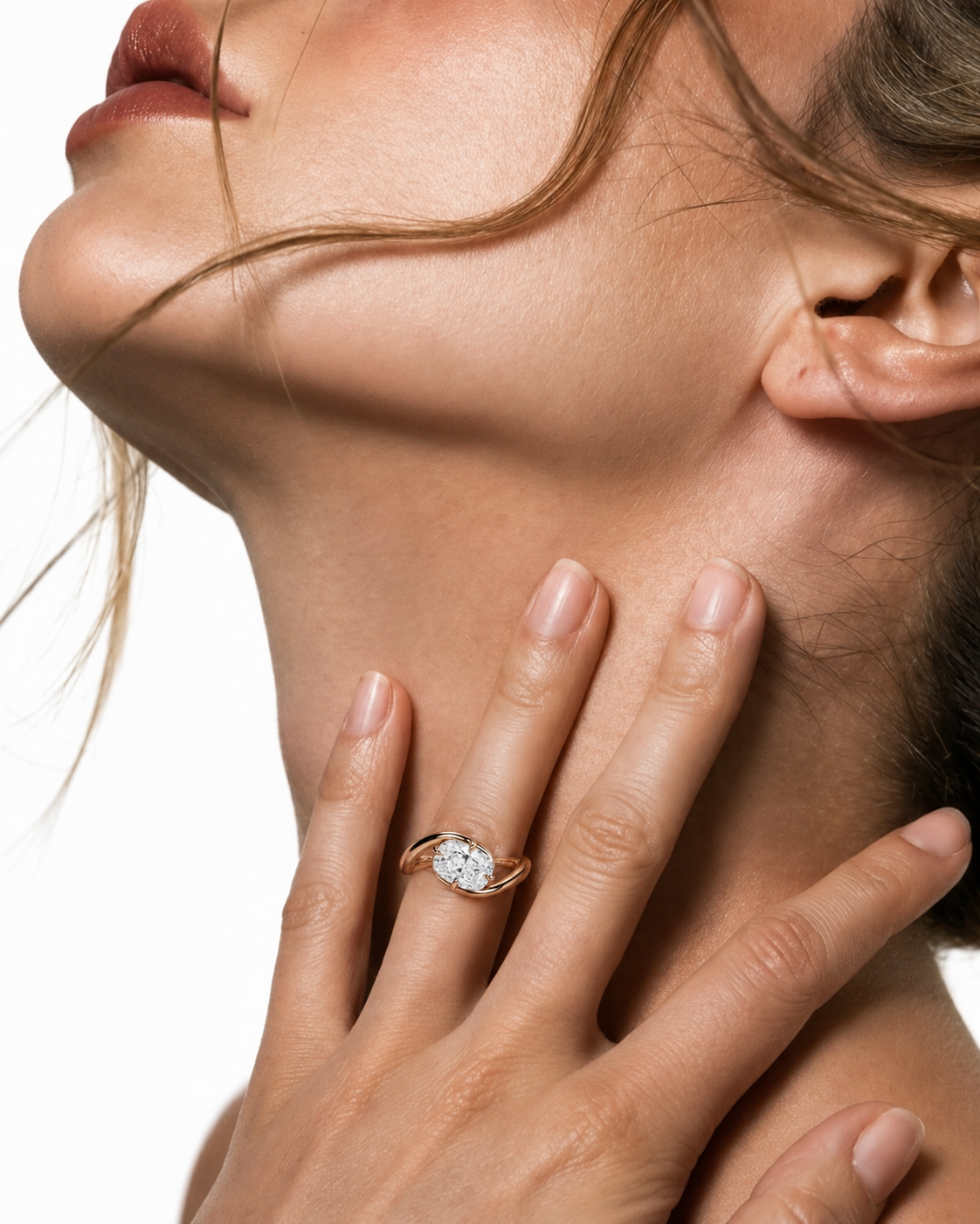 color_10K_RG, color_14K_RG &&close-up lifestyle shot of a woman wearing a gold ring with a clear round-cut gemstone on her finger, with her hand resting on her neck against a white background.