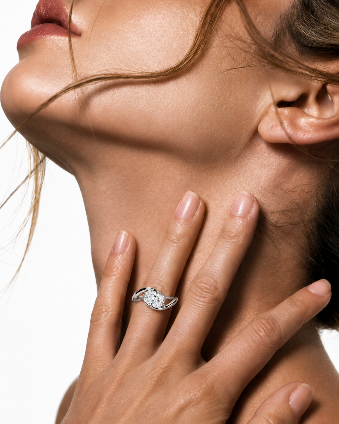 color_925_SIL,color_935_ARG,color_10K_WG, color_14K_WG &&A close-up lifestyle shot of a woman's hand resting on her neck, wearing a silver ring with a clear gemstone.