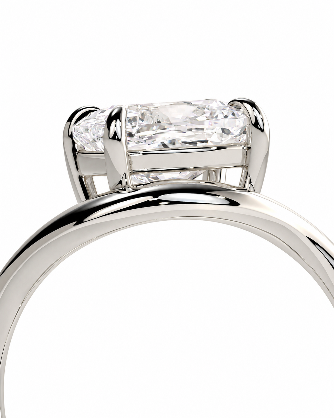 color_925_SIL,color_935_ARG,color_10K_WG, color_14K_WG &&A close-up of a silver-toned ring featuring a rectangular radiant-cut clear gemstone in a four-prong setting, flanked by two smaller round-cut stones, on a plain white background.
